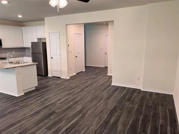 a view of kitchen view wooden floors appliances and cabinets