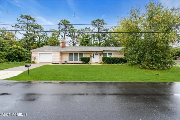 a front view of a house with a yard and trees