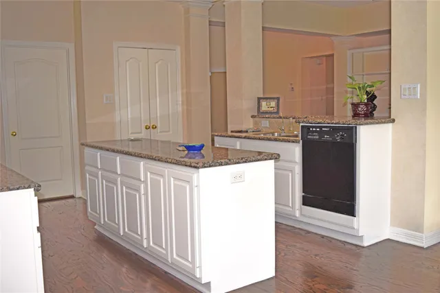 a kitchen with kitchen island granite countertop white cabinets and white appliances