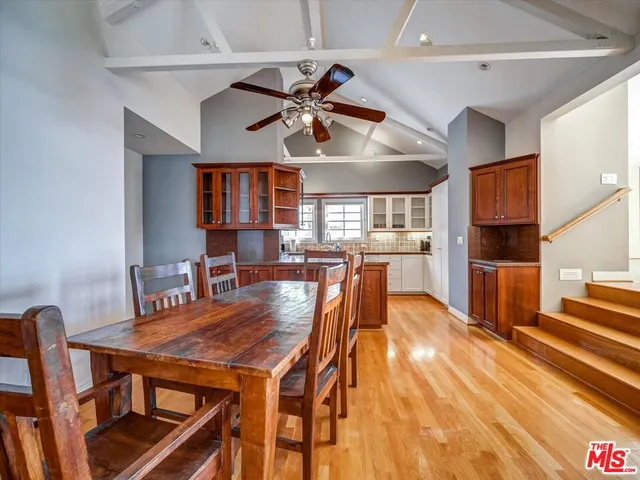 a dining room with wooden floor and chandelier