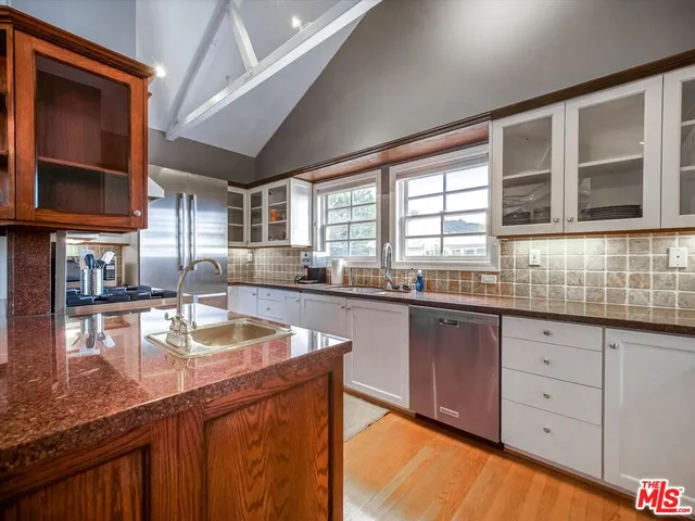 a kitchen with granite countertop a stove sink and cabinets
