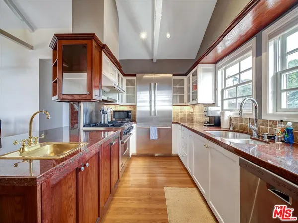 a kitchen with stainless steel appliances granite countertop a sink and a stove