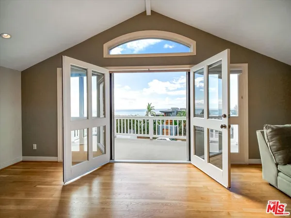 a view of a hallway with wooden floor and windows