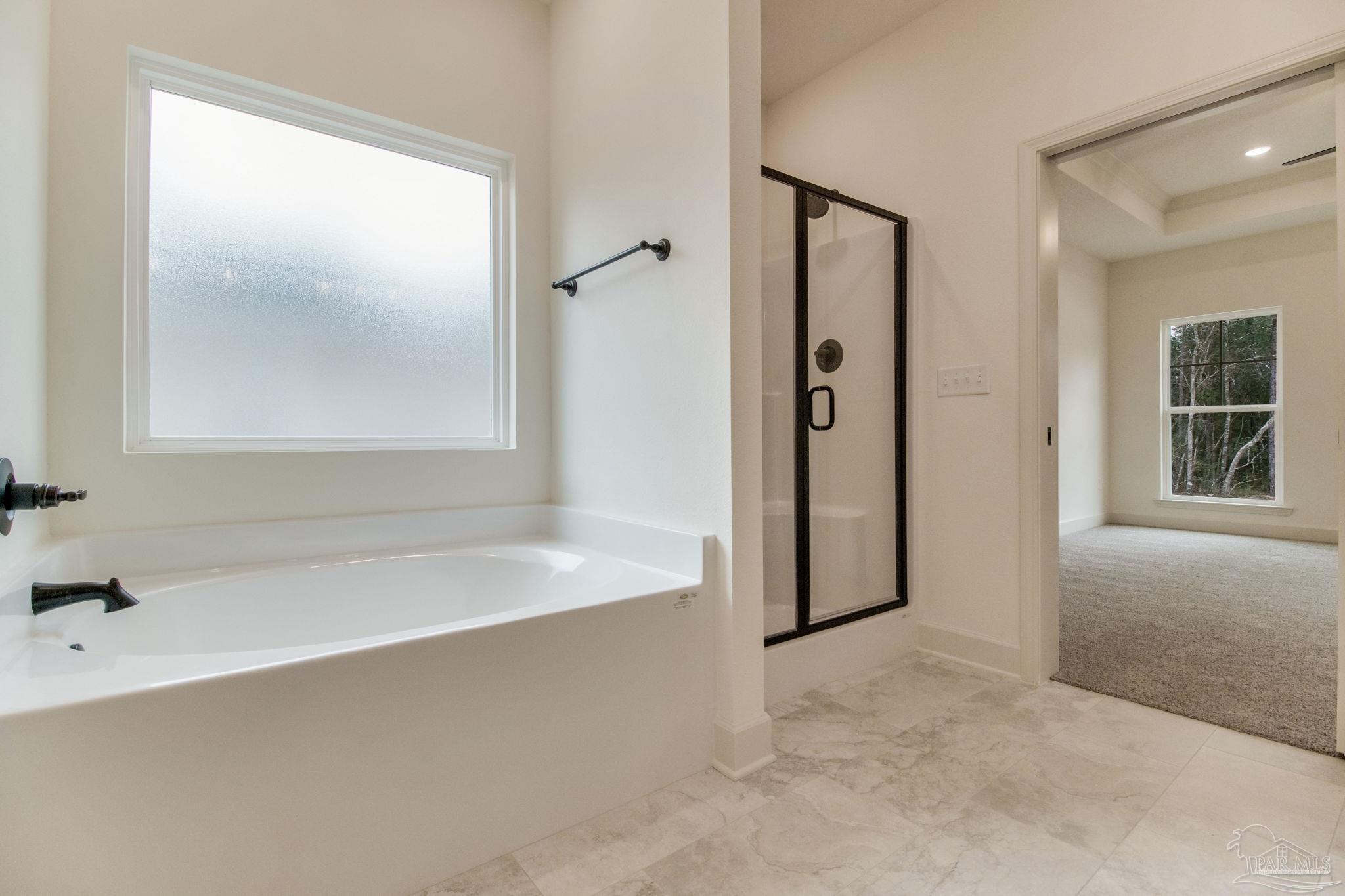 4310 Watkins Street Pace, FL 32571 - Photo 42 of 58 a bathroom with a bathtub and a shower