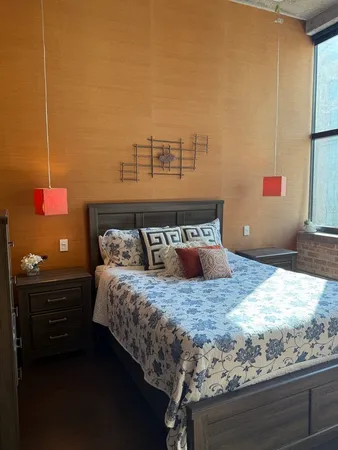 a bed sitting in a bedroom next to a window