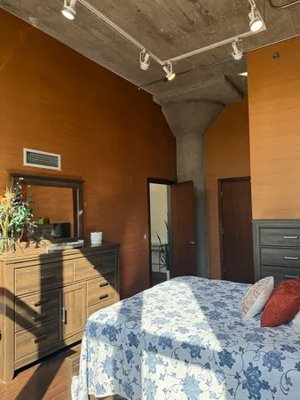 a bedroom with a bed and wooden floor