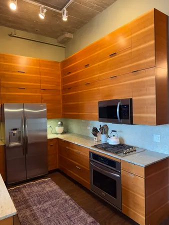 a kitchen with stainless steel appliances kitchen island granite countertop a sink and cabinets