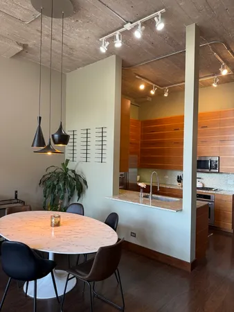 a kitchen with a table chairs and a wooden floor