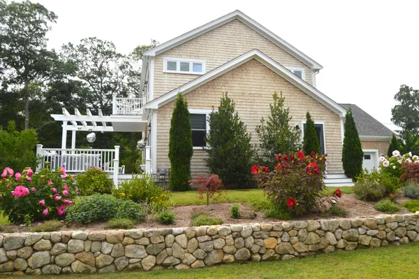 a front view of a house with a yard and potted plants