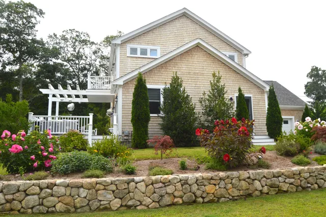 a front view of a house with a yard and potted plants