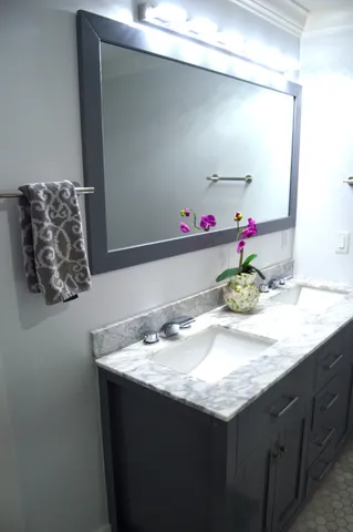a bathroom with a granite countertop sink and a mirror