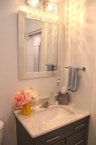 a bathroom with a granite countertop sink and a mirror