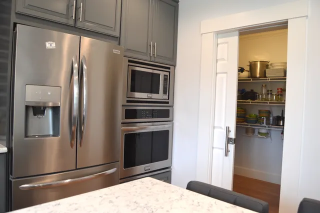 a kitchen with stainless steel appliances granite countertop a refrigerator and a sink