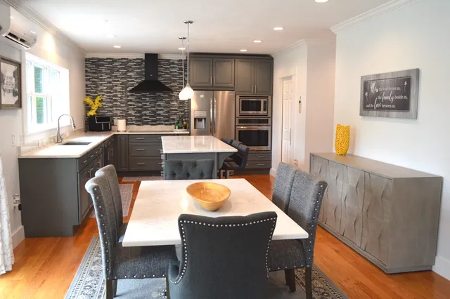a dining room with furniture and a large window