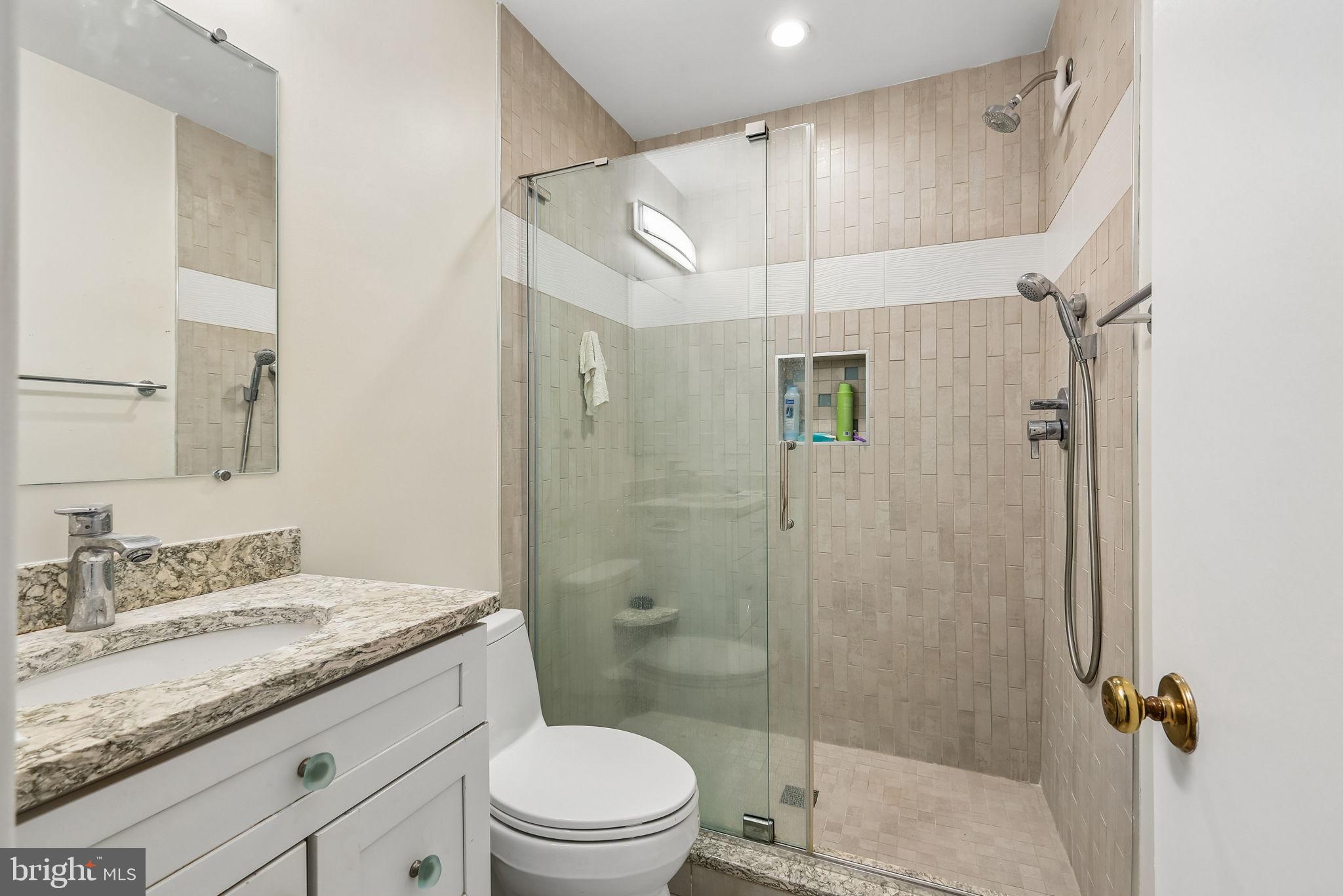 11714 Dry River Court Reston, VA 20191 - Photo 10 of 24 a bathroom with a granite countertop sink a mirror a shower and toilet