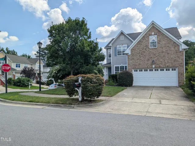 a front view of a house with a yard and a garage