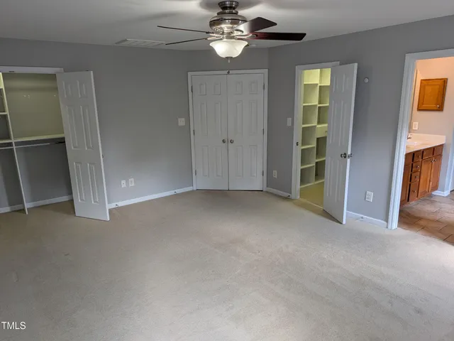 an empty room with closet and windows