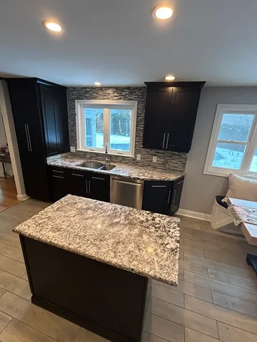 a kitchen with granite countertop stainless steel appliances and wooden cabinets