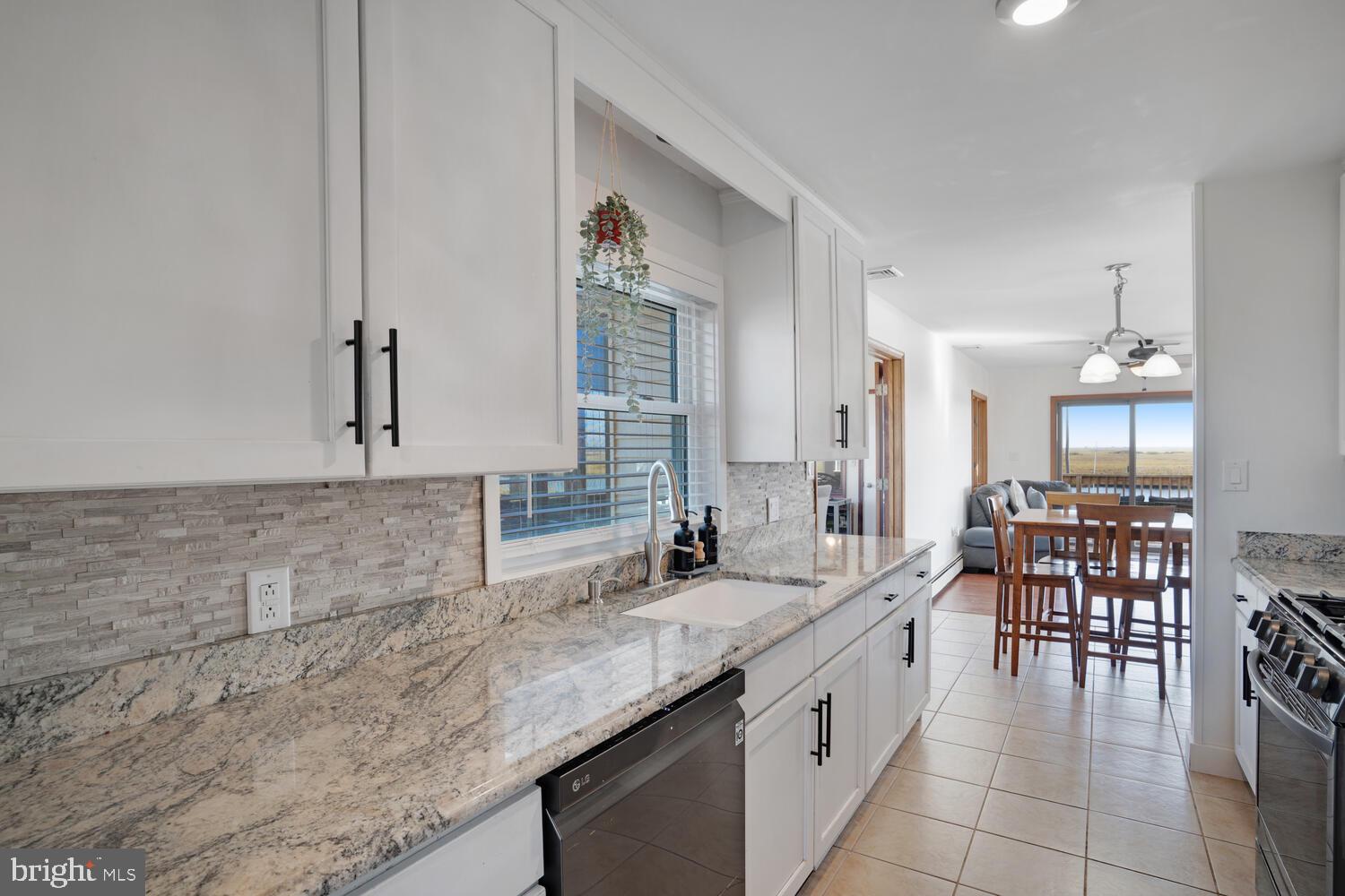 322 Dock Road West Creek, NJ 08092 - Photo 32 of 49 a kitchen with granite countertop a sink and white cabinets