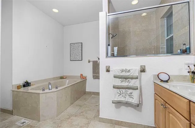 a bathroom with a tub a sink and a mirror