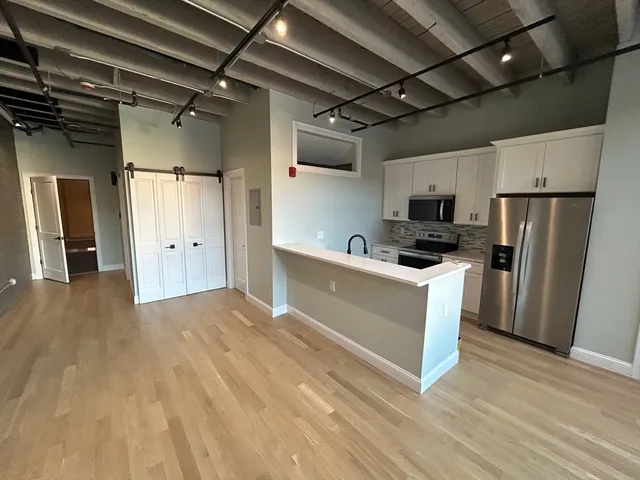 a kitchen with refrigerator cabinets and wooden floor