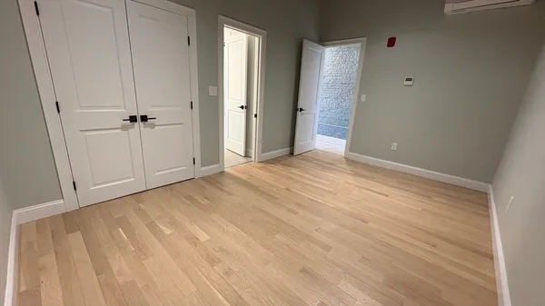 a view of an empty room with wooden floor