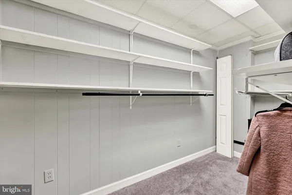 a view of walk in closet with empty racks