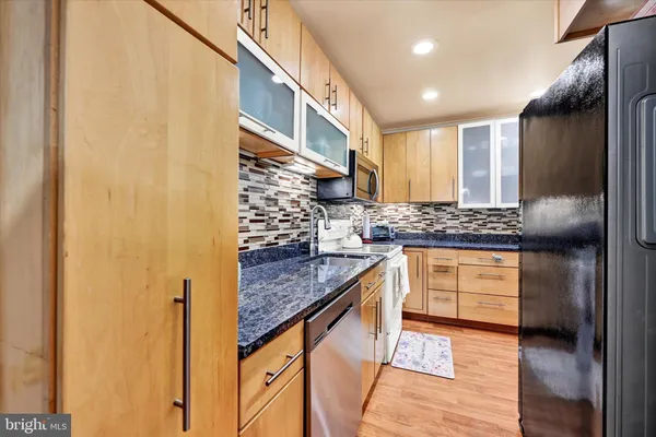 a kitchen with stainless steel appliances granite countertop a stove a sink and a refrigerator