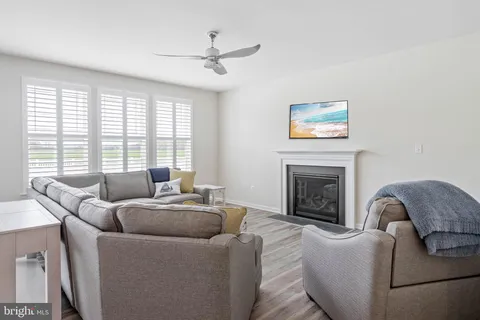 a living room with furniture a large window and a fireplace