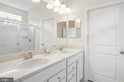 a bathroom with double sink and a mirror