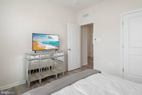 a bedroom with bed and a flat screen tv
