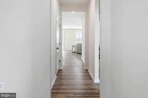 a view of a hallway with wooden floor and staircase