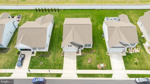 an aerial view of a house with a garden and lake view