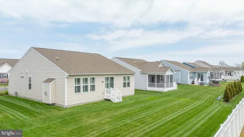 a view of a house with a big yard and large trees