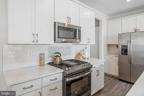 a kitchen with appliances a sink and cabinets