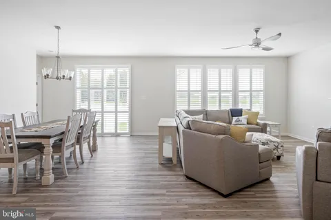 a living room with furniture a large window and wooden floor