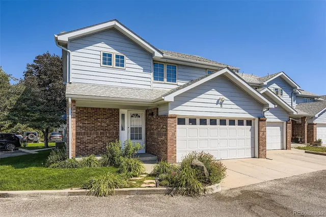 a view of a house with a yard and potted plants