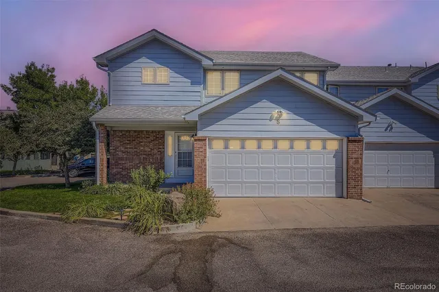 a front view of a house with a garden and garage