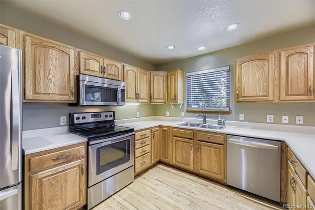 a kitchen with granite countertop a sink stainless steel appliances and cabinets