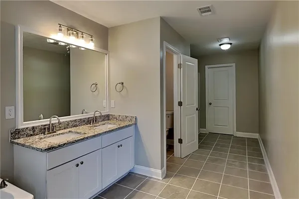a bathroom with a granite countertop sink a mirror and a shower