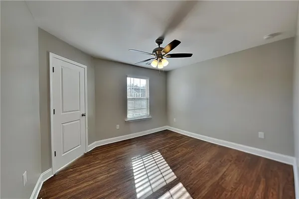 a view of an empty room with window and wooden floor