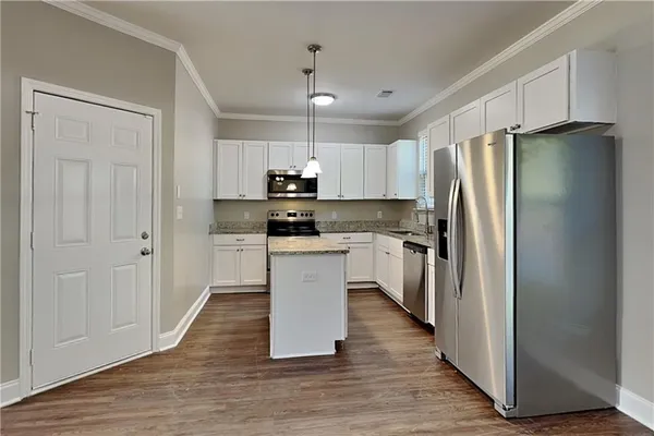 a kitchen with white cabinets and stainless steel appliances