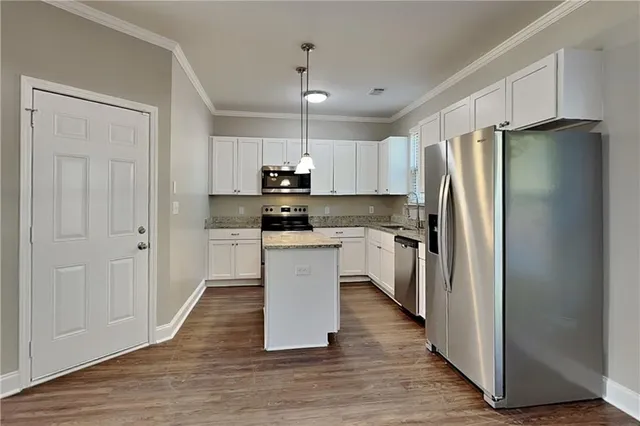a kitchen with white cabinets and stainless steel appliances