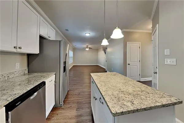 a kitchen with granite countertop sink refrigerator and microwave