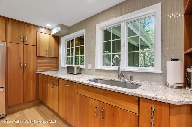 a kitchen with stainless steel appliances granite countertop a sink and a window