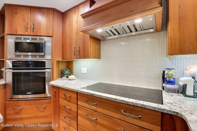 a kitchen with granite countertop cabinets stainless steel appliances and wooden floor