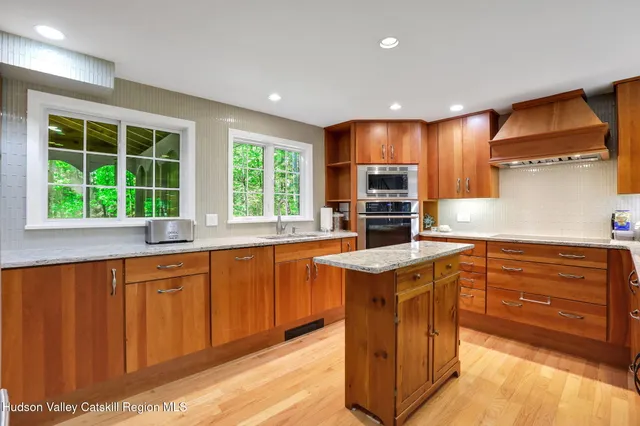 a kitchen with stainless steel appliances granite countertop wooden cabinets a stove and a sink