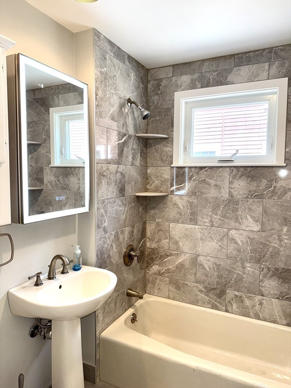 39 Newman Road Malden, MA 02148 - Photo 13 of 27 a bathroom with a sink a mirror and a bathtub
