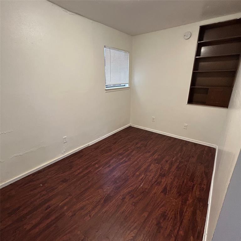 1011 West 23rd Street, Unit 102 Austin, TX 78705 - Photo 10 of 10 a view of an empty room with wooden floor and windows