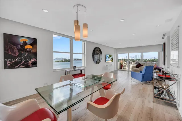 a living room with furniture kitchen view and a large window